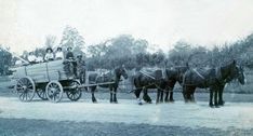 a group of people riding on the back of a horse drawn carriage