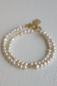 This is not your average pearl bracelet... Our Pearl Double Wrap Bracelet with white pearls features a double wrap style with with gold beaded accents. Wear solo or stacked with your favorite pieces! Materials: Medium pearls and gold filled beads with a gold plated coin ending. Length: Measures an adjustable 14-15" with an inch and a half extender Bead Bracelets Aesthetic, Double Wrap Bracelet, Beads Bracelet Design, Jewelry Accessories Ideas, Prom Jewelry, Classy Jewelry, Jewelry Essentials, Jewelry Lookbook, Girly Jewelry