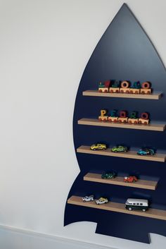 there are many toy cars on the shelves in this display case that is designed to look like a rocket ship