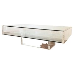 a glass and chrome coffee table with two shelves on each side, in the shape of a rectangle