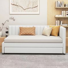 a white couch sitting in front of a book shelf