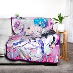 a couch covered in a blanket with anime characters on it