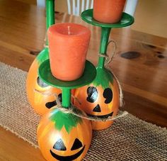 three pumpkin candles are sitting on top of each other