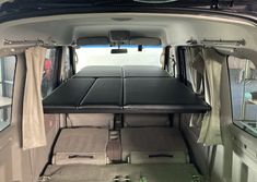 the interior of a van with seats and tables in place for people to sit down