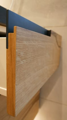 a close up view of a wooden headboard on a bed with white and blue sheets