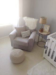 a baby's room with a crib, rocking chair and white rugs