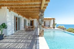 a house with a large swimming pool next to the ocean