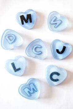 the letters are made out of glass and have black lettering on them, as well as blue gummy hearts