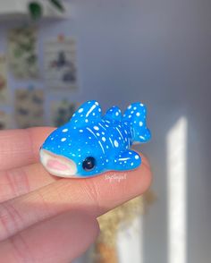 a hand holding a blue and white toy fish