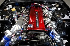 the engine compartment of a sports car with red and blue exhaust pipes on it's hood