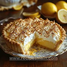 a lemon pie on a plate next to sliced lemons