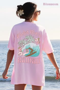 "This Hawaii Crewneck Comfort Colors shirt is perfect for those who love and travel to Hawaii. Featuring a vibrant surf design accented by hibiscus flowers, it's a colorful and comfortable addition to any wardrobe. The shirt proudly displays \"Aloha State Hawaii\" in bold funky retro letters, making it a great way to show your love for the beautiful state. ABOUT THE SHIRT Comfort Colors 1717 Unisex Jersey Short Sleeve 100% Ringspun Soft Cotton Fits True To Size Size UP 1-2 Sizes For An Oversized Look RETURN POLICY All items are made to order specially for you! We do not accept returns or exchanges unless the item is printed incorrectly. We want you to love your order, so please be sure to check size charts and ask any questions if you have any! Let me know if you have any questions at all! Vacation Surfing T-shirt With Crew Neck, Hawaii Clothes, Hawaii Crewneck, Hawaii Tshirt, Love And Travel, Retro Letters, Vacation Tshirt, Vacation Tshirts, Hawaii Outfits