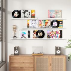 an entertainment center with record players and records on the wall