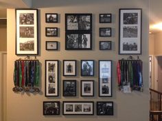 a wall filled with pictures and medals hanging on it's side walls in a hallway