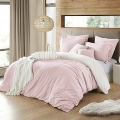 a bed with pink and white comforters in a bedroom