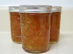 three jars filled with food sitting on top of a white counter next to each other