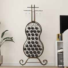 a metal rack with lots of black and white balls on it next to a potted plant