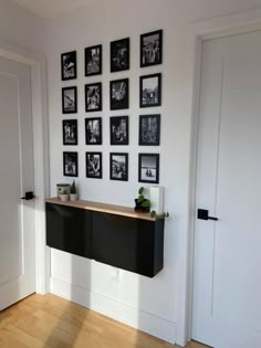 there is a black and white wall with pictures on the wall next to each other