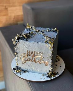 a birthday cake sitting on top of a plate with gold confetti around it