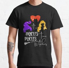 a man wearing a black t - shirt with the words hoccus pocus and three witches on it