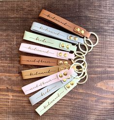 a bunch of keys that are sitting on top of a wooden table with some writing on them