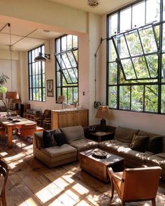 a living room filled with lots of furniture and large windows over the top of it