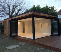 a small wooden structure with glass doors on the outside, and wood decking around it