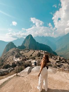 a woman standing on top of a dirt hill