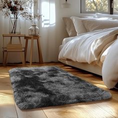 a bedroom with white walls and wooden floors, an area rug that looks like fur is on the floor