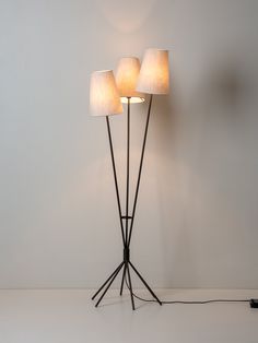 three lamps sitting on top of a white floor