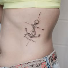 an anchor tattoo on the side of a woman's stomach