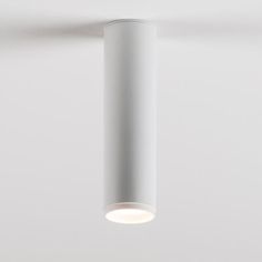 a white light hanging from the ceiling in an empty room with no one around it