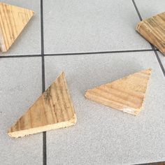 three pieces of wood sitting on top of a tile floor next to each other,