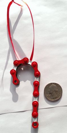 a penny sitting next to a red necklace