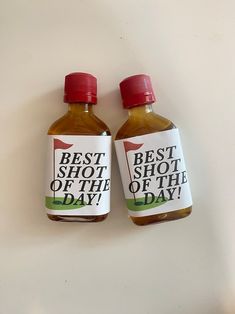 two bottles of hot sauce sitting next to each other on a white counter top with the words best shot of the day printed on them