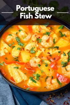 a bowl filled with shrimp and potatoes next to cilantro on top of a table