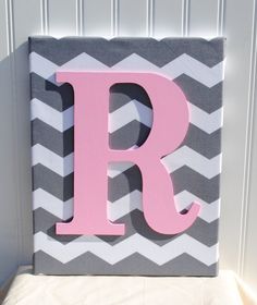 the letter r is painted in pink and grey chevrons on a gray and white background