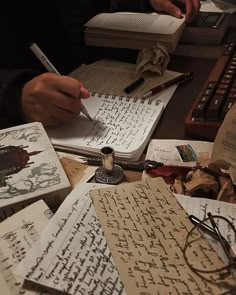 an image of someone writing on paper with some typewriters in front of them