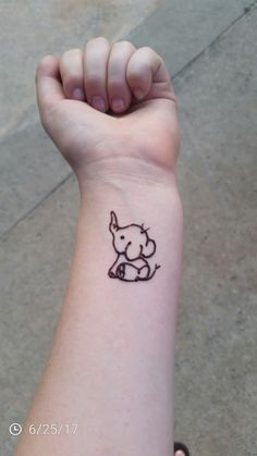 a small tattoo on the wrist of a person with a little dog in it's lap