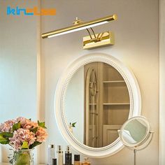 a bathroom vanity with flowers on it and a mirror over the sink that has lights above it