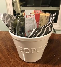 a wine bottle in a white bucket with black and white napkins