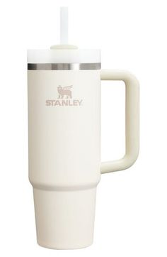 a white travel mug with a straw in the cup and stanley logo on the side