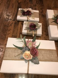 three wrapped presents with flowers on them sitting on a wooden floor next to each other