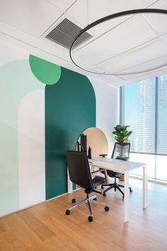 an office with a desk and chair in front of a large window, next to a potted plant