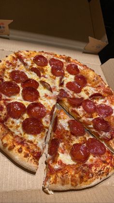 a pepperoni pizza sitting in a box with one slice taken out of it's side