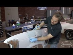 a man waxing a white car in a garage