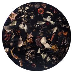 a black plate with flowers and leaves on it