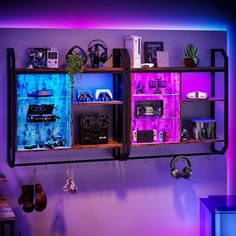 an entertainment center is lit up with purple and blue lights in the corner, along with other items