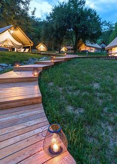 a wooden walkway leading to some tents at night