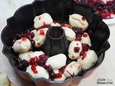 a pan filled with dumplings and cranberry sauce on top of a table